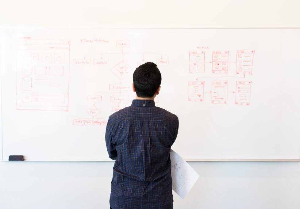 person standing by a whiteboard