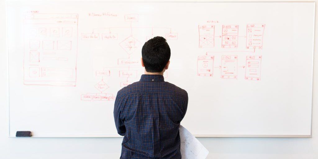 person standing by a whiteboard