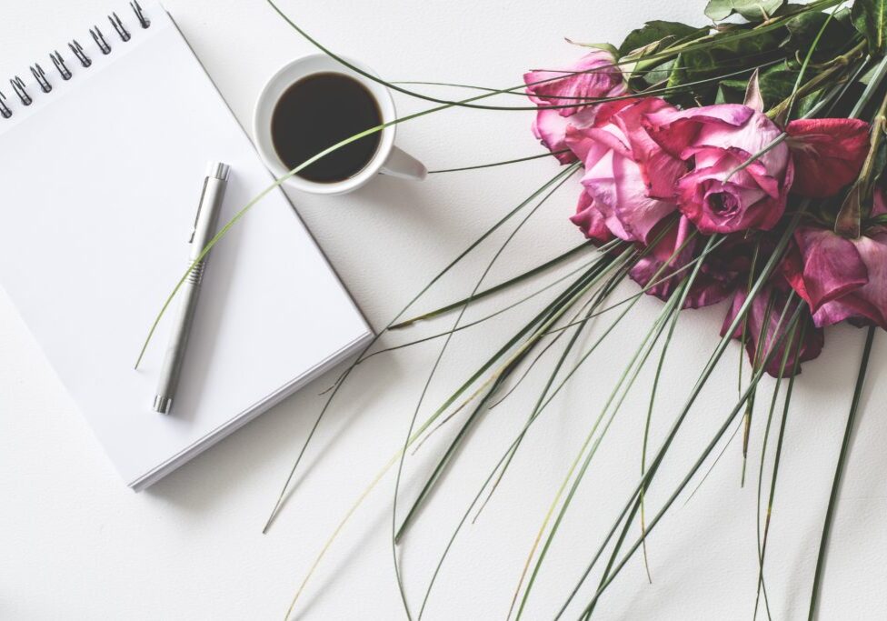 flower with pen and paper next to it