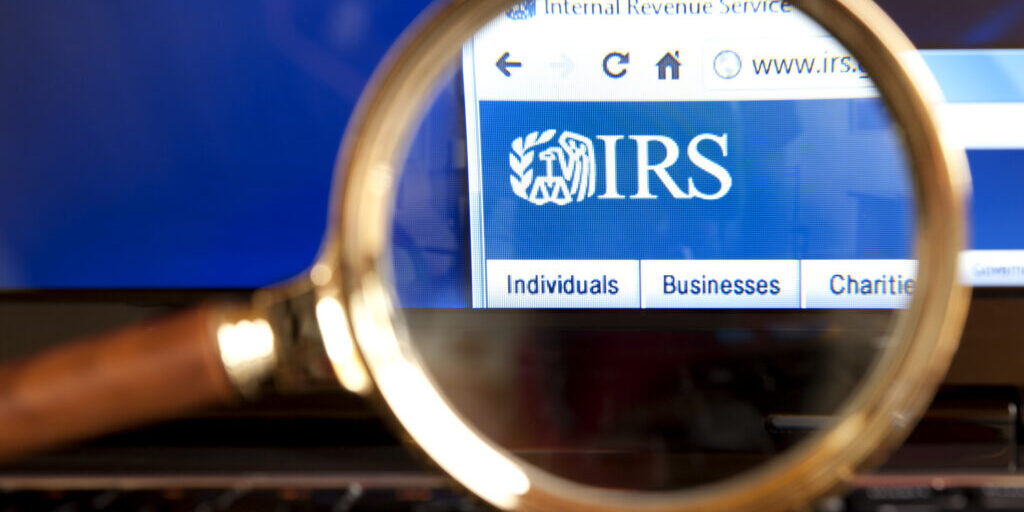 "Izmir, Turkey - June 12, 2012: Close up to IRS( Internal Revenue Service) website through a magnifying glass on the laptop. IRS is a United States government agency tasked with collecting yearly state and income tax from working residents and businesses."