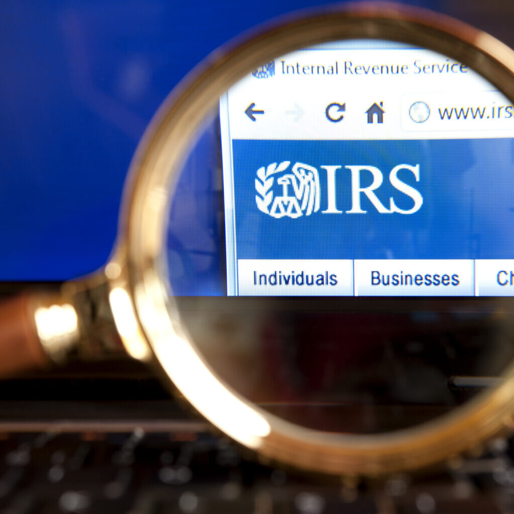 "Izmir, Turkey - June 12, 2012: Close up to IRS( Internal Revenue Service) website through a magnifying glass on the laptop. IRS is a United States government agency tasked with collecting yearly state and income tax from working residents and businesses."