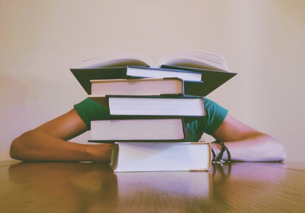 student-behind-stack-of-books
