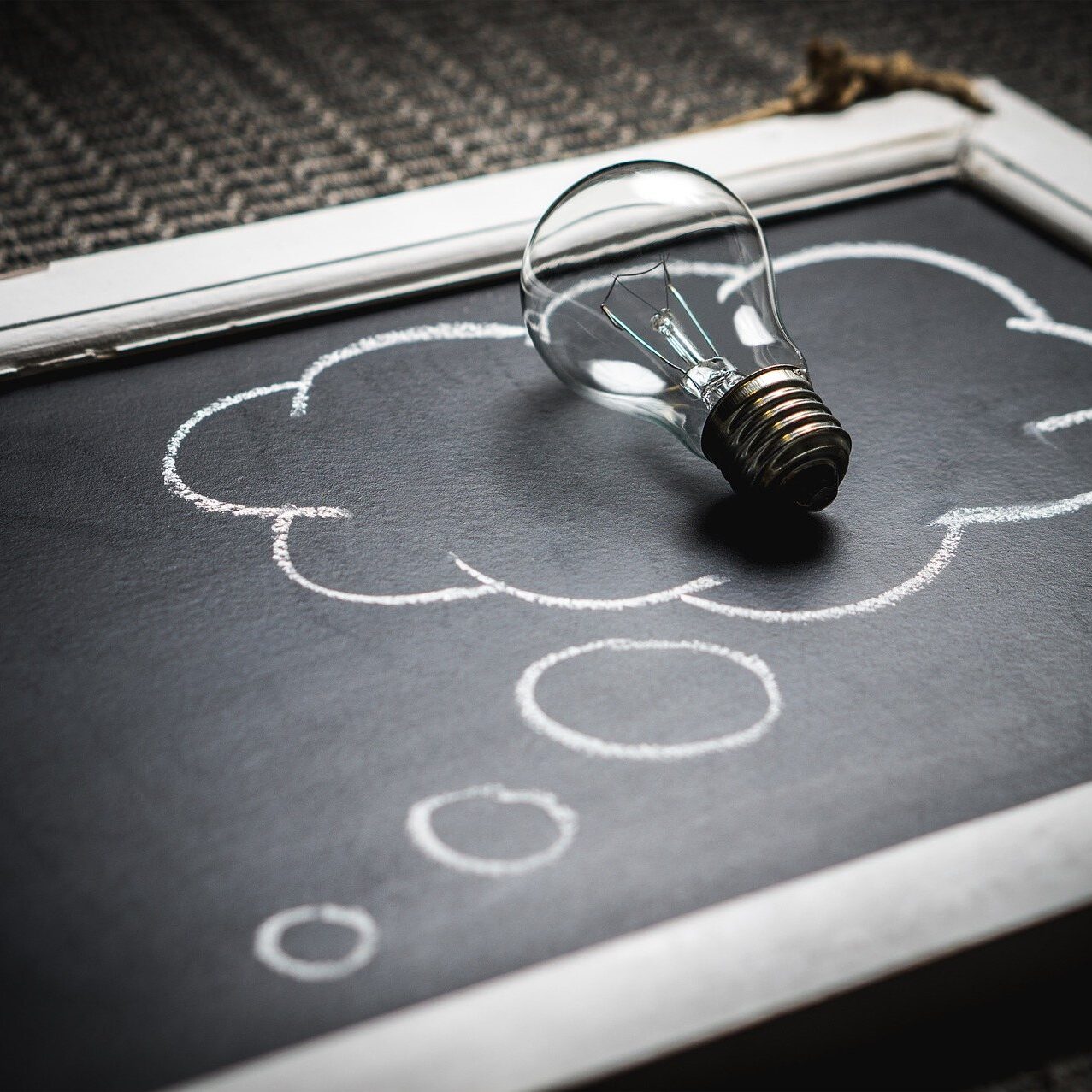 Nonprofit-idea-light-bulb-on-chalkboard thought bubble with a lightbulb inside